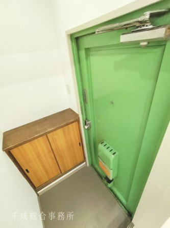 グリーンの玄関扉と下駄箱。