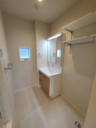 三面鏡シャワー付き洗面台。洗濯機置き場には可動式の棚があって便利