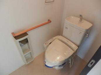 手すりも付いたトイレ。温水洗浄便座付きです。