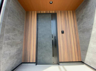 木目調の外壁と重厚感のある玄関ドア