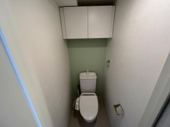 温水洗浄便座付きのトイレです。上部に収納棚が付いています。