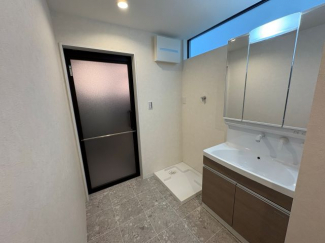 洗面所の右側にも収納あり。上部のスリット窓が明るさを取り入れます。ちょうど良い広さです。