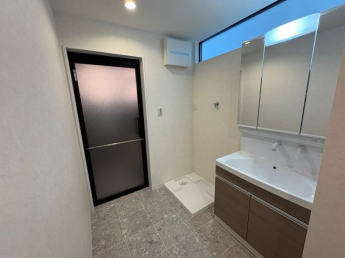 洗面所の右側にも収納あり。上部のスリット窓が明るさを取り入れます。ちょうど良い広さです。