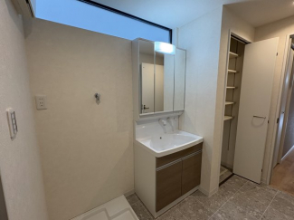 洗面所の右側にも収納あり。上部のスリット窓が明るさを取り入れます。ちょうど良い広さです。