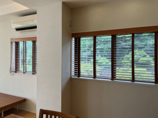 LDKのウッドブラインドの角度を変えたら外の緑が見えて気持ち良い。ロケーションの良さもこの物件の特徴。＊写真の家具や照明等はつきません。