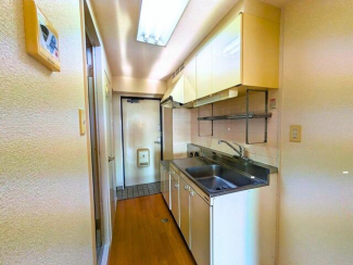 廊下型のキッチンは吊戸棚＆ラック付きで、調理道具をまとめて収