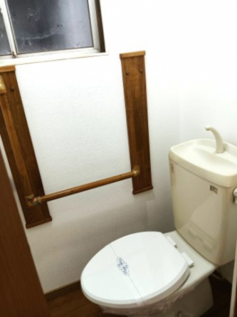 落ち着いた色調のトイレです。手すり付きです。