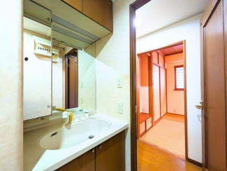 木目調の収納が温かみを演出する洗面台。室内の雰囲気にも馴染む