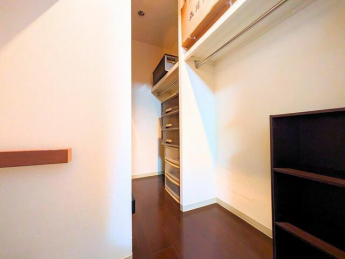 ハンガーパイプや収納棚が備え付けられたウォークインクローゼッ