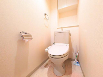 清潔感のある白を基調としたトイレは、手洗い付きタンクや収納棚