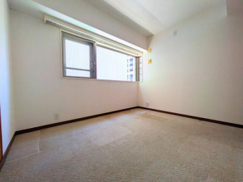 窓からの採光が心地よい洋室。ゆったりとしたスペースがあり、ベ