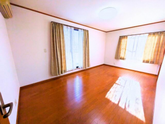 二面の採光で明るい洋室。壁面がフラットで収納家具を並べやすい