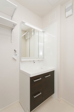 三面鏡シャワー付き洗面台です。洗濯機置き場には稼働棚があって便利♪