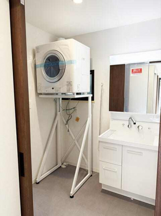 シャンプーもできるシャワー水栓つきの洗面台と、ガス衣類乾燥機