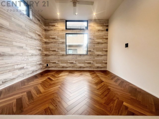 大きな採光窓から光が差し込む、明るく開放的なリビング。ヘリンボーンの床材が上質な雰囲気を添え、日々の暮らしを心地よく彩ります。