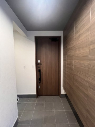 木目調の玄関ドアと、タイル貼りのポーチ。左側には土間収納有。