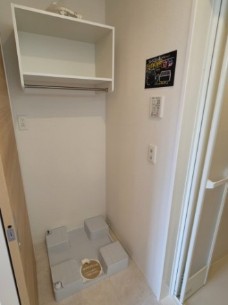 室内洗濯機置き場です。上部に棚もあって洗剤などもストックしておけますね。
