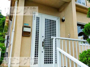 ツーロック鍵の白い扉の玄関です。玄関前には大きな木がありある