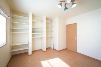 １階洋室は７．５帖の広さ。壁一面に収納棚があって、“しまう”