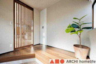 リビングドアから光が漏れる、温かみを感じられる玄関スペースで