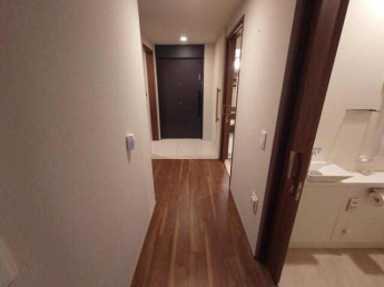 バリアフリーですっきりとした廊下周り、玄関には手摺りと荷物置