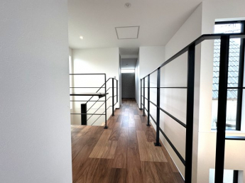 吹抜に面した廊下が、上下階をゆるやかにつなぎ、開放感と一体感のある空間を演出。光と視線が抜けることで、家全体に広がりと心地よさをもたらします。